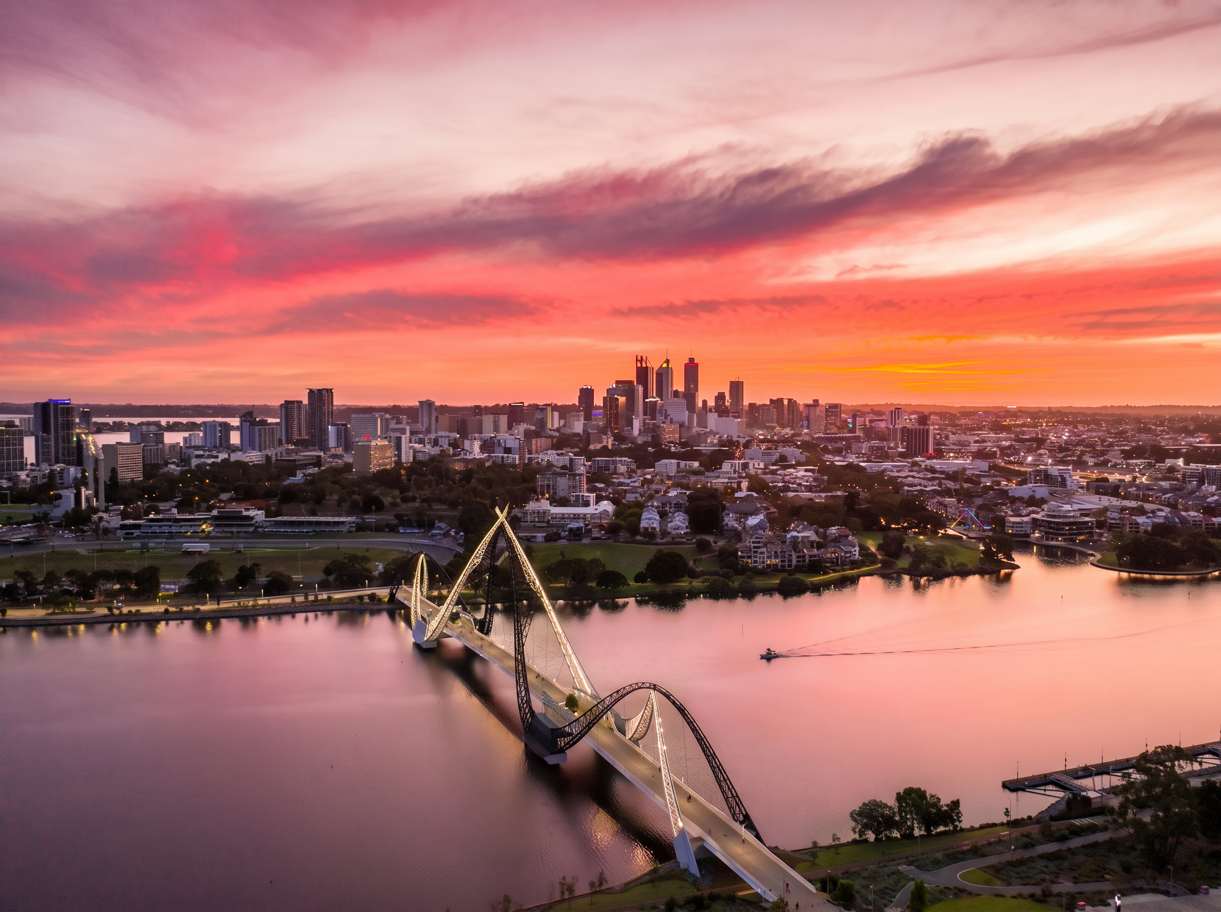 Matagarup Bridge lit at sunset across the Swan River with the Perth city skyline in Western Australia